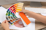Woman with color palette samples at table, closeup