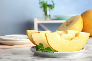 Plate with fresh delicious melon slices on table