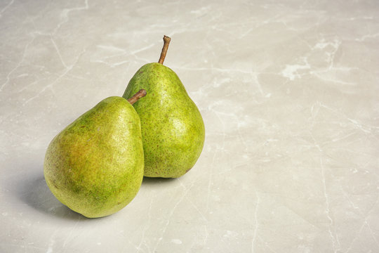 Ripe pears on grey background. Space for text
