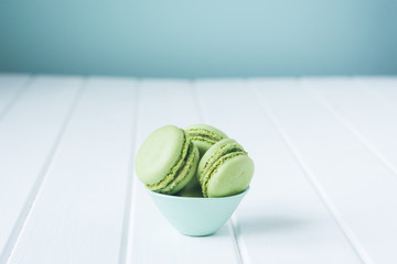 green lime or pistachio flavored macarons in a small blue dish