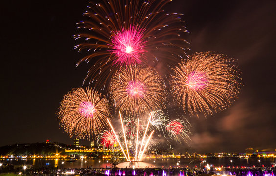 Golden, pink, and white fireworks during a summer festival in Quebec City, Canada.
