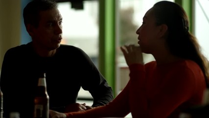 Portrait shot of a handsome Hispanic and beautiful wife speaking calmly before clinking their bottles and taking a sip of beer
