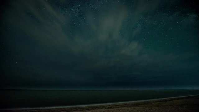 Time-lapse. Starry night with thunderstorm and lightning over the sea