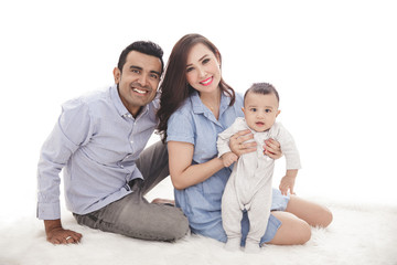 happy family with cute son sitting on the floor while smiling on