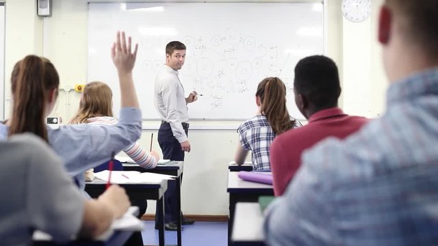 Male High School Tutor At Whiteboard Teaching Science Class