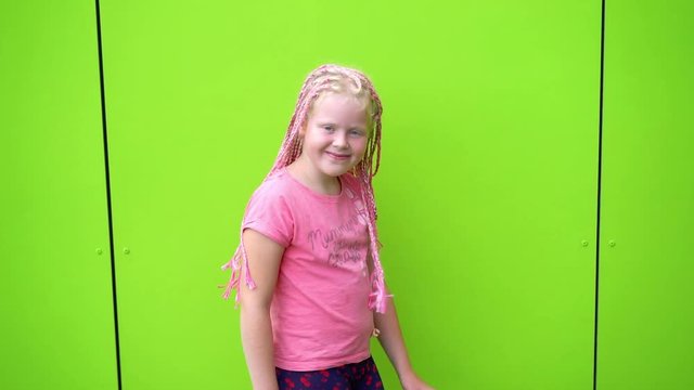the beauty of slow motion - portrait of a beautiful light-skinned little girl of a non-standard modern appearance - with pink African plaits of zizi