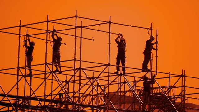workers silhouette at sunset builders collect the design. construction workers concept building silhouette men slow motion lifestyle video group