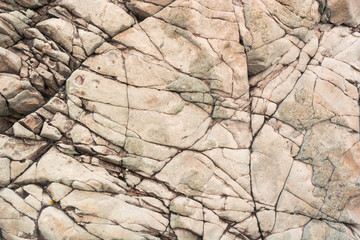 Natural pattern of cracks on a stone of warm color.