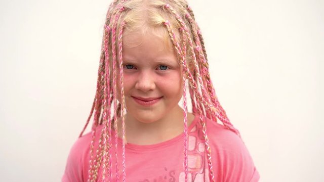 portrait of a beautiful light-skinned little girl of a non-standard modern appearance - with pink African plaits of zizi