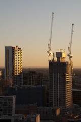 Fototapeta na wymiar Sydney Australia, New high rise towers under construction with urban sprawl in background at dusk