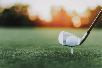 Foto op Plexiglas Golfstick en golfbal op standaard op groen veld. © VadimGuzhva