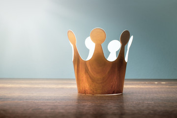 cardboard golden crown on wood table with morining light.
