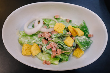 vegetables salad with ham and bread on top