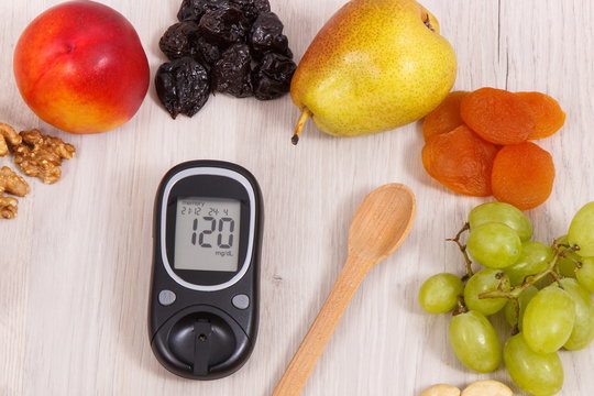 Glucose meter with sugar level and food as source minerals, vitamins and fiber, diabetes and healthy nutrition concept