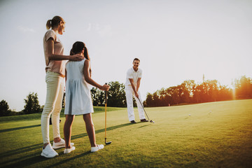 Happy Young Family Relax on Golf Field in Summer.