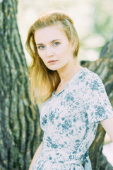 Naklejka premium beautiful girl in the Park, in a summer dress and walking. Smiles and enjoys nature. St. Petersburg, Yelagin island