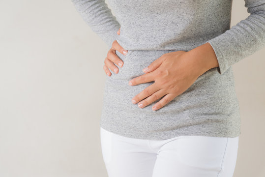 Young woman having painful stomachache. Chronic gastritis. Abdomen bloating concept.