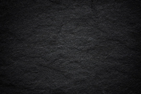 Dark grey black slate background or natural stone texture.