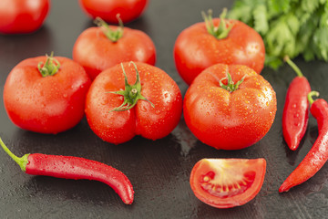 Fototapeta premium Chili tomatoes garlic and other spices for making ketchup on black background.