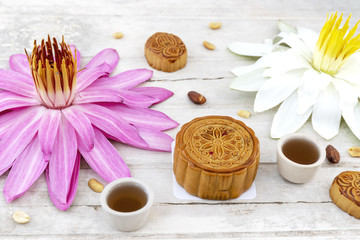Obraz na płótnie Canvas Flat lay of Mid Autumn festival Moon cake on old white table with pink water lily 