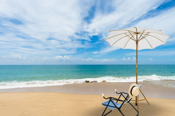 Beach chair with white umbrella tropical beach in summer. Vacation and travel concept.