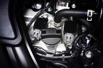 Engine oil cap installed on a car engine for maintenance service lubricant, automotive part concept.