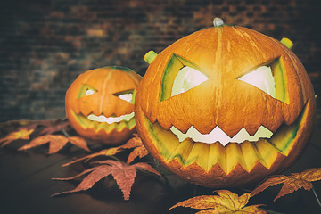 Halloween pumpkin on black wooden table with brick background. Halloween holiday concept.