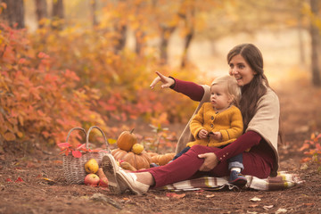 Happy family mother and child daughter playing in nature autumn park on sunset