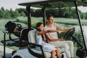 Young Mother and Daughter with Cart on Field.