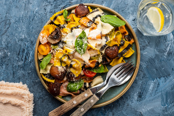 Pasta Farfalle with mushrooms, basil, tomatoes and cream sauce. Italian traditional cuisine. Mediterranean food