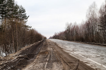 Dull, dirty road in early spring, late autumn or winter in Russia