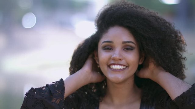 Smiling young black woman. Joy, positive and love. Beautiful african-style hair.