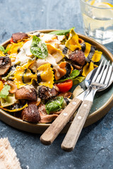 Pasta Farfalle with mushrooms, basil, tomatoes and cream sauce. Italian traditional cuisine. Mediterranean food