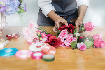 Obraz na płótnie Canvas Woman hands making flower composition at florist workshop. Do it yourself concept