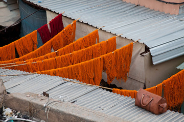Rot und Orange gefärbte marokkanische Wolle in Marrakesch hängt zum Trocknen