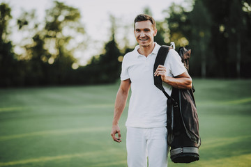 Young Man in White Clothes Playing Golf on Field.