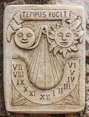 Antique marble sundial clock with a Latin inscription meaning time flies in  a picturesque medieval city of Eze France