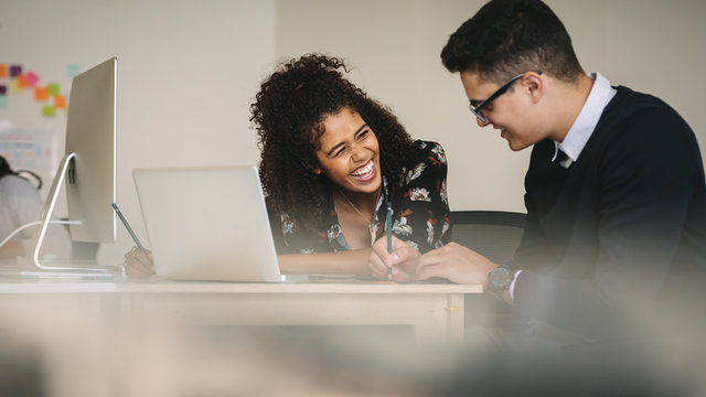 Businesswoman laughing during a discussion with colleague at wor