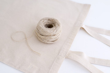 Fototapeta na wymiar Cotton bag and coil of rope isolated on white