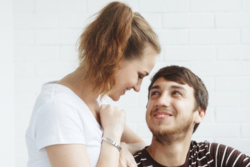 Happy girl and guy, cute couple looking out the window in their new home