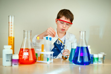 Cute boy is making science experiments in a laboratory