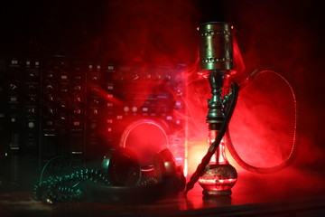 Shisha party club concept. Dj mixer with on dark nightclub background with stylish oriental shisha.