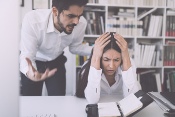 Businessman yelling at female colleague in office