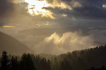 Dramatic rain clouds and thick mist at sunset, in the mountains, in summer
