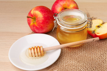 Jewish holiday Rosh Hashanah background with honey and apples on wooden table.