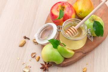 Jewish holiday Rosh Hashanah background with honey and apples on wooden table.