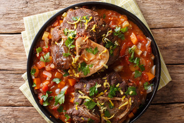 beef shank Ossobuco alla Milanese with gremolata and spicy sauce closeup. horizontal top view