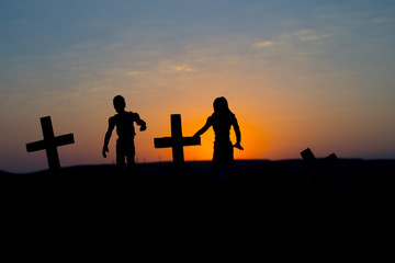 Fototapeta na wymiar Silhouette some zombies on the cemetery walking around at sunset