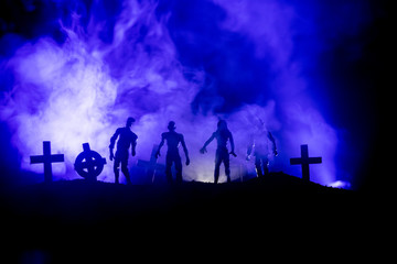 Scary view of zombies at cemetery dead tree, moon, church and spooky cloudy sky with fog, Horror Halloween concept.