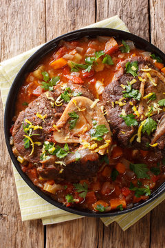 beef shank Ossobuco alla Milanese with gremolata and spicy sauce closeup. Vertical top view